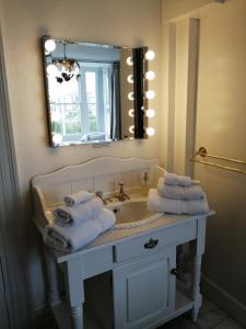 uma casa de banho com lavatório, espelho e toalhas em The Pier em Portsmouth