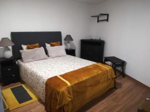 Un dormitorio con una cama con una manta amarilla. en Eiras do Dão en Penalva do Castelo