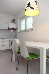 - une cuisine avec une table et des chaises blanches dans l'établissement Koper Homey Retreat LURE, à Koper