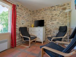 a living room with two chairs and a tv at Pretty Holiday Home in Courry with Swimming Pool in Courry