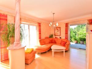 a living room with an orange couch and a table at Apartment near the river in Deggendorf Bavaria in Deggendorf