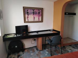 einen Schreibtisch mit einem Computer und einem Stuhl in einem Zimmer in der Unterkunft Gal - Habitaciones Confortables in Cuernavaca