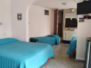 Un dormitorio con una cama azul y una sala de estar. en Gal - Habitaciones Confortables, en Cuernavaca