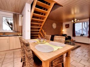 een keuken en eetkamer met een houten tafel bij Small simple and reasonably priced semi detached house with its own terrace in Houffalize