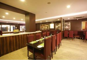 a restaurant with a table and chairs and a bar at Hilarity Inn in Pedappai