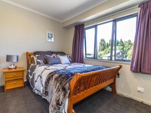 a bedroom with a bed and a window at Kowhai Heights - Ohakune Holiday Home in Ohakune