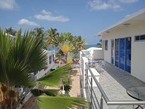 a balcony with tables and chairs and palm trees at Hotel Portobello in Coveñas