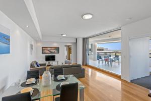 a living room with a couch and a table at Tweed Ultima Apartments in Tweed Heads