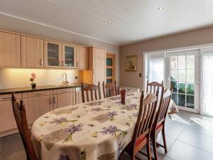 een eetkamer met een tafel en een keuken bij Delightful cottage surrounded by nature in Warneton