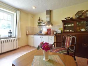 eine Küche mit einem Tisch mit einer Vase mit Blumen darauf in der Unterkunft Romantische Ferienwohnung in Boldenshagen in Boldenshagen