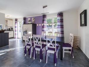 レリクにあるThatched Holiday Home in Rerik with Terraceの紫の壁のキッチン&ダイニングルーム(テーブル、椅子付)