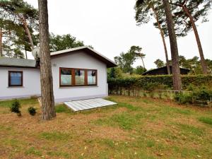 a white house with trees in the yard at Cosy Holiday Home in Am Salzhaff by the Sea in Pepelow