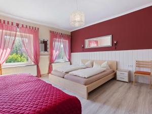 1 dormitorio con cama y pared roja en Elegant apartment with garden in Gingst, en Gingst