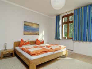 um quarto com uma cama com almofadas laranja em Apartment with garden in F rstenwalde em Fürstenwalde-West