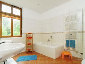 a white bathroom with a tub and a sink at Apartment with garden in F rstenwalde in Fürstenwalde-West