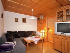 a living room with a couch and a tv at Spacious apartment near the ski area in Steingaden