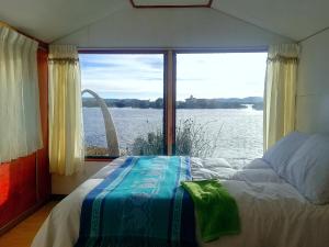 um quarto com uma cama e vista para a água em Titicaca em Puno