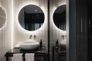 a bathroom with two sinks and two mirrors at Bellwort Hotel in Guadalajara