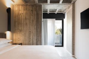 a bedroom with a white bed and wooden walls at Bellwort Hotel in Guadalajara