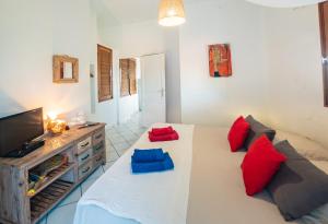 a living room with a couch with red and blue pillows at Bungalow Anse Figuier in Terre-de-Haut