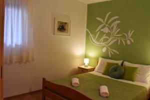 sypialnia z łóżkiem i zieloną ścianą w obiekcie Apartments Frama - 3 apartments w Bol