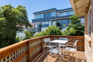 a patio with a table and chairs on a balcony at Reflections on the Bay in Hobart