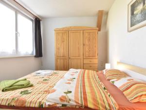 レリクにあるSpacious Apartment in Rerik Germany near Seaのベッドルーム1室(ベッド1台付)、木製キャビネットが備わります。