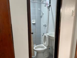 a bathroom with a toilet and a shower at Philippa's Bed and Breakfast in Iloilo City