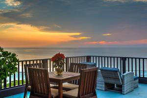 una mesa y sillas en un balcón con vistas al océano en Punta Zicatela Hotel - Adults Only, en Puerto Escondido