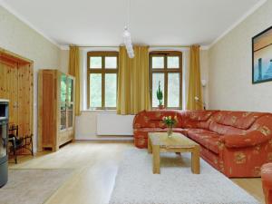 uma sala de estar com um sofá vermelho e uma mesa em Apartment with garden in F rstenwalde em Fürstenwalde-West