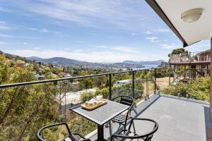 a patio with a table and chairs on a balcony at The Lookout in Hobart