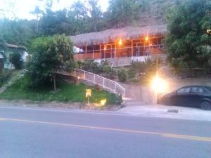 une maison sur une colline avec une voiture garée devant elle dans l'établissement Hostal Cristal, à Los Naranjos