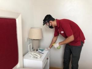 un uomo è in piedi accanto a un tavolo con una lampada di White Tree Residence a Giacarta