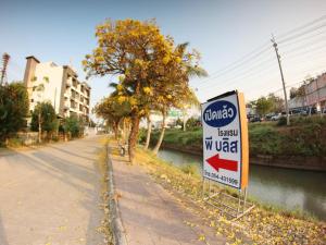 a sign for a gas station next to a street at P Bliss hotel in Phayao