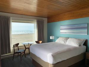 a bedroom with a bed and a view of the beach at The Ocean Front at Seaside in Seaside