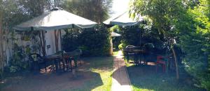 een patio met een parasol en een tafel en stoelen bij Preston Pointe Resort in Kisii