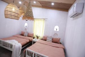 a bedroom with two beds and a tv and a tv at EVA HUT Mui Ne Beach Hostel in Mui Ne