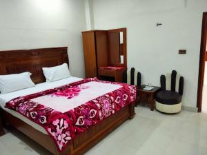 a bedroom with a large bed with a red blanket at New Royal Residency PECHS in Karachi