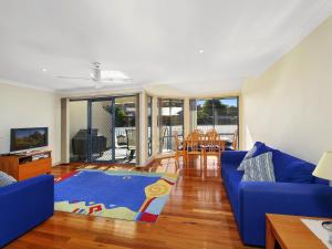 a living room with a blue couch and a blue rug at Family Beach Retreat in Lovely Terrigal Home in Terrigal