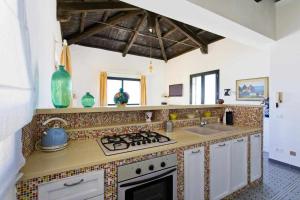 una cucina con piano cottura e lavandino di Dune Home alloggi sul mare ad Alcamo Marina