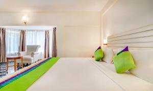 根尼亚古马里RR INN Group Of Hotels的一间卧室配有一张大床,提供绿色和紫色枕头