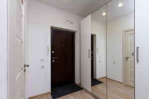 a hallway with a black door and a mirror at New Avrora in Novosibirsk