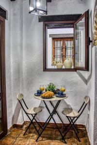 een tafel met eten en twee stoelen in een kamer bij Casa Tiberíades in Córdoba