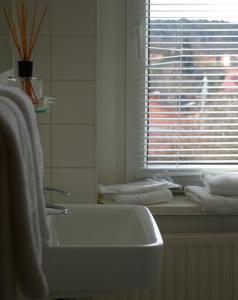 a bathroom with a sink and a window and towels at Hotel & Restaurant Bergschlösschen in Buckow +32 photos