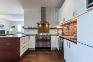 a kitchen with white cabinets and a stove at UrbanStyle Claremont Apartment in Perth