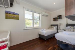 a bedroom with two beds and a window at UrbanStyle Claremont Apartment in Perth