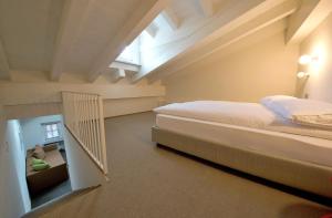 um quarto no sótão com uma cama e uma janela em Apartements Coeur de Ville em Aosta