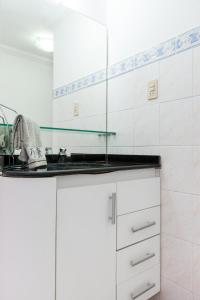 a white kitchen with white cabinets and a sink at Boa Viagem Flat in Recife