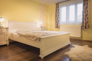 1 dormitorio con cama blanca y ventana en Casa Sasului, en Bazna