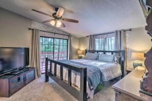 a bedroom with a bed and a flat screen tv at Relaxing Lincoln Forest Retreat with Wraparound Deck in Cloudcroft